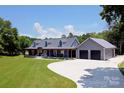 Stunning home featuring a long driveway, beautiful landscaping and a welcoming covered front porch at 265 St Matthews Church Rd, Salisbury, NC 28146