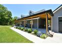 Side view of long covered front porch with furniture, leading to a well-maintained lawn at 265 St Matthews Church Rd, Salisbury, NC 28146