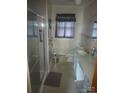 Bathroom with white tile, updated vanity, shower, and a decorative window curtain at 2815 Highland Dr, Lincolnton, NC 28092