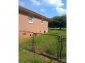 Exterior shot of a brick home and chain link fence surrounded by green grass at 2815 Highland Dr, Lincolnton, NC 28092