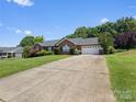 Wide driveway leading to a well-maintained brick home, complemented by lush green lawn at 3906 Brickfield St, Hickory, NC 28602