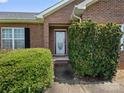 Inviting front entrance with a decorative door, flanked by manicured greenery and black shutters at 3906 Brickfield St, Hickory, NC 28602