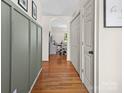 Bright hallway featuring hardwood floors, decorative wall paneling, and an arched entryway at 3906 Brickfield St, Hickory, NC 28602