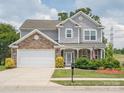 Charming two-story home features a manicured lawn and a stone and gray shingle facade at 4090 Sunset Dr, Rock Hill, SC 29732
