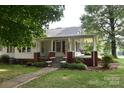 Charming home with covered porch and swing, landscaped yard, and inviting walkway at 4143 E Maiden Rd, Maiden, NC 28650
