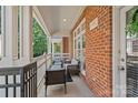 Cozy outdoor seating on the covered porch with brick facade at 4708 S Hill View Dr, Charlotte, NC 28210