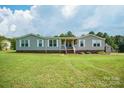 Charming single-story home featuring a welcoming front porch, gray siding, and a well-maintained lawn at 6785 Knotty Wood Ln, Vale, NC 28168