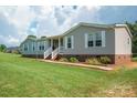 Charming single-story home featuring a welcoming front porch, gray siding, and a well-maintained lawn at 6785 Knotty Wood Ln, Vale, NC 28168