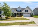 Beautiful two-story home with manicured lawn, stone details, and ample parking with a two-car garage at 6907 Hunts Mesa Dr, Fort Mill, SC 29707