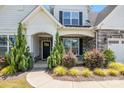 Inviting entrance with stone accents, lush landscaping, and a covered front porch, creating curb appeal at 6907 Hunts Mesa Dr, Fort Mill, SC 29707