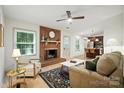 Bright and open living room with a brick fireplace and views into the modern kitchen at 9334 New Towne Dr, Matthews, NC 28105
