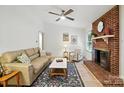 Comfortable living room featuring hardwood floors, a brick fireplace, and ample seating at 9334 New Towne Dr, Matthews, NC 28105