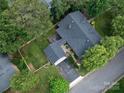 Aerial view of a home with lush greenery, a gray roof, a patio with outdoor seating and a paved driveway at 112 8Th Nw Ave, Hickory, NC 28601