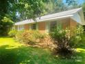 Brick house with green shutters and mature trees and manicured bushes at 1834 Sharonwood Ln, Rock Hill, SC 29732