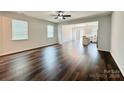 Spacious living room featuring wood flooring, plentiful natural light, and modern ceiling fan at 211 Surrey Oak Ln, Charlotte, NC 28216