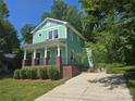 Inviting two-story home with a quaint front porch and a long concrete driveway at 405 S South St, Gastonia, NC 28052