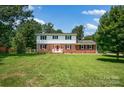 Two-story brick home with a well-manicured lawn and mature trees at 4121 Dover St, Claremont, NC 28610
