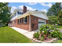 The home features a brick exterior, a two-car garage, and a beautiful flower garden at 4121 Dover St, Claremont, NC 28610