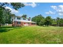 A expansive yard surrounds this two-story home with mature trees at 4121 Dover St, Claremont, NC 28610