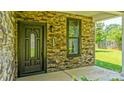 Inviting front entry with a decorative door, stone accents, and ample natural light at 5511 Milhaven Ln, Charlotte, NC 28269