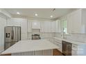 Bright kitchen featuring white cabinets, stainless steel appliances, and a large center island at 5511 Milhaven Ln, Charlotte, NC 28269