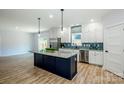 Stylish kitchen with a large island, stainless steel appliances, and modern backsplash at 7039 Executive Cir, Denver, NC 28037