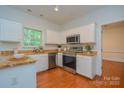 Modern kitchen with granite countertops, stainless steel appliances, white cabinetry and hardwood floors at 8510 Glade Ct, Huntersville, NC 28078