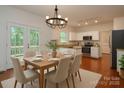 Bright kitchen and dining area with white cabinets, stainless steel appliances, and hardwood floors at 8510 Glade Ct, Huntersville, NC 28078