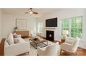 Bright and airy living room with a fireplace, large windows, and a ceiling fan at 8510 Glade Ct, Huntersville, NC 28078