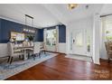 Elegant dining room featuring hardwood floors, stylish chandelier, and blue accent wall at 958 Skywater Dr, Fort Mill, SC 29715