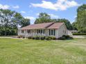 Well-maintained single-story home with a lush green lawn and mature trees surrounding the property at 1302 Hawthorne Rd, Lancaster, SC 29720