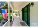Inviting front porch with a vibrant green door, 'Welcome' mat, and American flag at 135 Primrose Dr, Salisbury, NC 28147