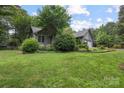 Gray home with lush green lawn and trees, offering a private and serene setting at 140 Quiet Cove Rd, Mooresville, NC 28117