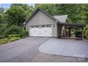 Side view of the two-car garage with gray siding and a covered carport at 140 Quiet Cove Rd, Mooresville, NC 28117