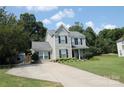 Charming two-story home with gray siding, black shutters and well-maintained landscaping at 148 W Walnut Ave, Mount Holly, NC 28120