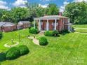 Beautiful brick home with a large front lawn, stately columns, outbuilding, and mature trees at 15 Kings Mountain St, York, SC 29745