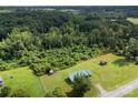 Expansive wooded property featuring a single-story home with green roof and several storage sheds at 223 Green Meadows Dr, Kings Mountain, NC 28086