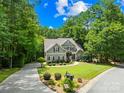 Beautifully landscaped home with lush greenery, a circular driveway, and classic architectural details at 2455 Talbot Ct, Sherrills Ford, NC 28673