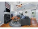 Living room with fireplace, hardwood floors, vaulted ceiling, and access to the kitchen at 2510 Cranbrook Ln, Charlotte, NC 28207