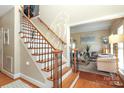 Inviting foyer with wood floors, staircase, and view into the living room at 3015 Rochester Ct, Monroe, NC 28110