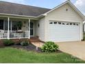 Welcoming home featuring a front porch and attached two-car garage at 3810 Spike Ln, Vale, NC 28168