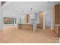 Bright, open kitchen with modern wood cabinets, an island with a white countertop, and sleek pendant lighting at 4208 Antioch Church Rd # 1, Weddington, NC 28104