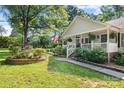 Beautiful home with lush landscaping, garden water feature, and inviting front porch at 4534 Pebblebrook Sw Cir, Concord, NC 28027