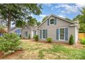 Side view of a single-story home featuring gray siding, blue shutters, and a well-maintained lawn at 5234 Bellflower Ln, Charlotte, NC 28227