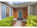 Inviting front porch featuring wood shingle accents, a blue front door, and lush landscaping at 5234 Bellflower Ln, Charlotte, NC 28227