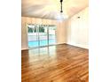 Bright living room with hardwood floors and sliding glass doors leading to a deck at 5234 Bellflower Ln, Charlotte, NC 28227