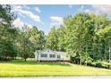 Charming one-story home surrounded by lush trees and a grassy lawn at 7154 Woodcock Trl, Stanley, NC 28164