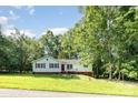 Charming one-story home surrounded by lush trees and a grassy lawn at 7154 Woodcock Trl, Stanley, NC 28164