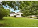 Lush green backyard featuring a well-maintained lawn, mature trees, and a cozy home at 80 Sumner Nw Ave, Concord, NC 28027