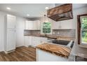 Modern kitchen with custom wood countertops, white cabinets, stainless steel appliances, and unique tile backsplash at 8337 Norcroft Dr, Charlotte, NC 28269